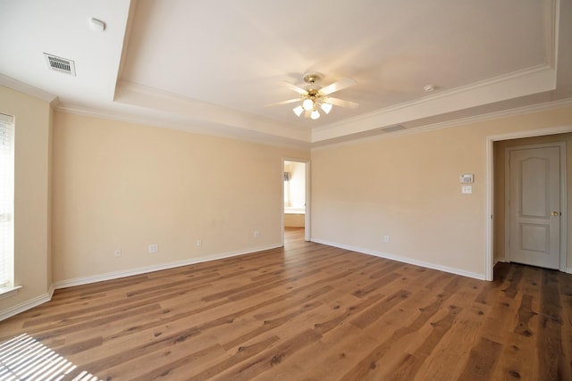 spare room featuring hardwood / wood-style floors, a tray ceiling, ceiling fan, and ornamental molding