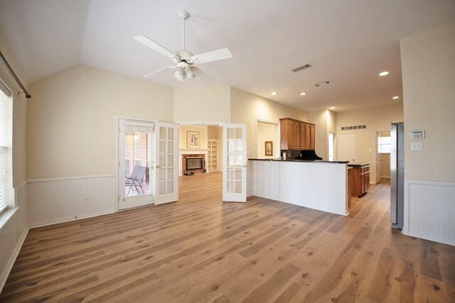 kitchen featuring hardwood / wood-style floors, french doors, vaulted ceiling, ceiling fan, and kitchen peninsula