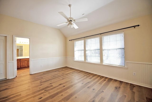 spare room with vaulted ceiling, ceiling fan, and light hardwood / wood-style flooring