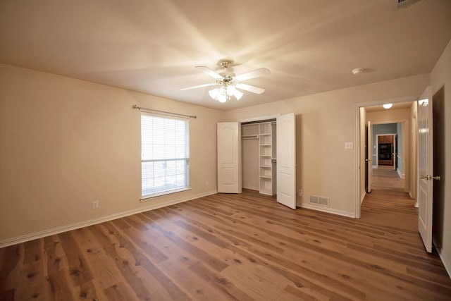 unfurnished bedroom with a closet, ceiling fan, and hardwood / wood-style floors