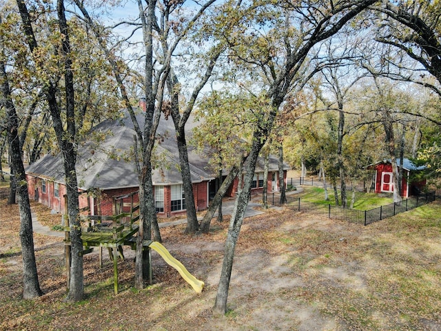 view of yard with a storage shed and a playground