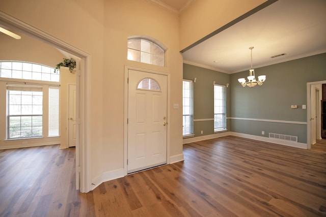 entryway featuring ornamental molding, dark hardwood / wood-style floors, and a chandelier