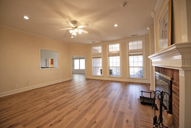 living room with hardwood / wood-style flooring, ceiling fan, ornamental molding, and a fireplace