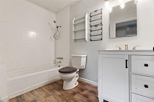 full bathroom with vanity, a textured ceiling, tiled shower / bath combo, hardwood / wood-style flooring, and toilet