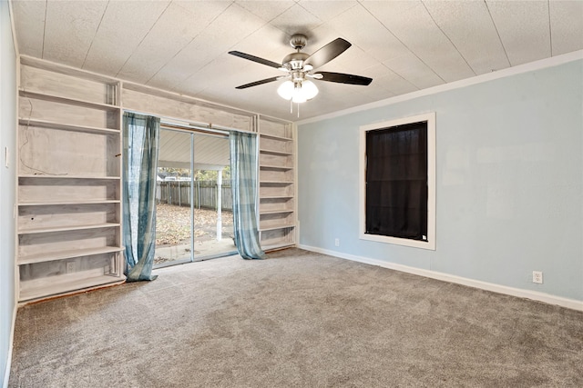 carpeted spare room featuring ceiling fan and crown molding