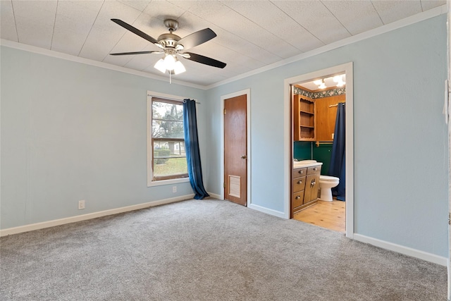 unfurnished bedroom with light carpet, ensuite bath, ceiling fan, and ornamental molding