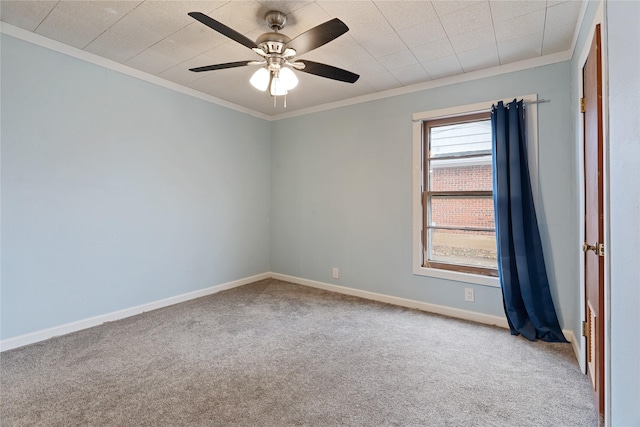 carpeted spare room featuring ceiling fan and crown molding