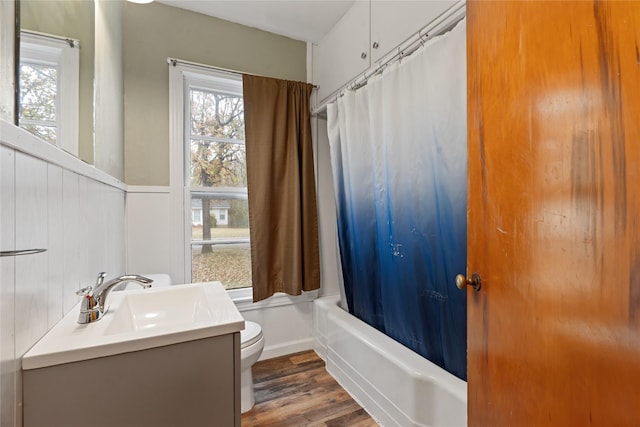 full bathroom featuring wood-type flooring, vanity, shower / tub combo, and toilet