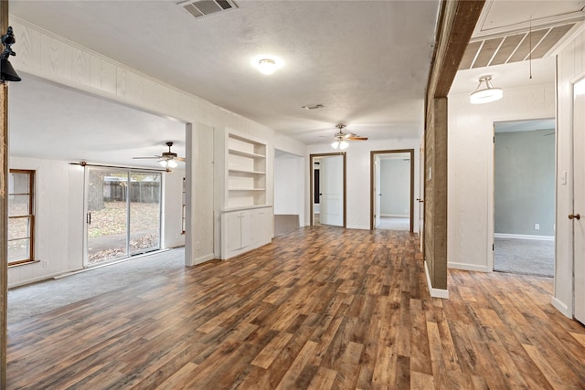 unfurnished living room with hardwood / wood-style floors, a textured ceiling, built in features, and ceiling fan