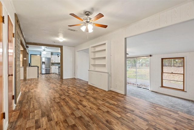 unfurnished living room featuring ceiling fan, built in features, and wood-type flooring