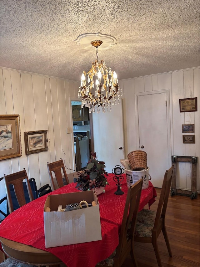 dining room featuring hardwood / wood-style floors, a textured ceiling, and a chandelier