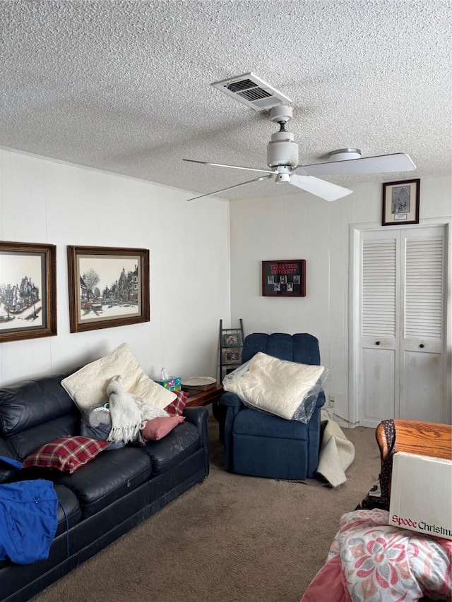 carpeted living room with a textured ceiling and ceiling fan