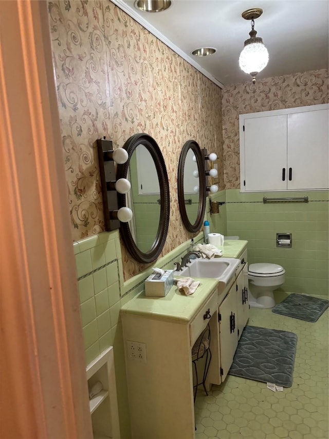 bathroom featuring vanity, toilet, and tile walls