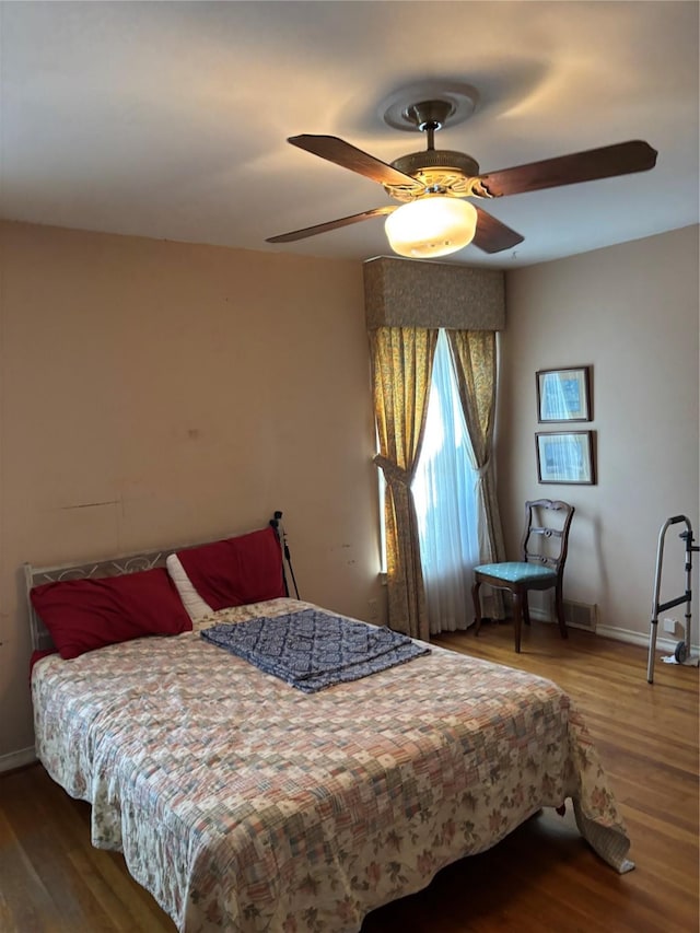 bedroom with ceiling fan and hardwood / wood-style floors