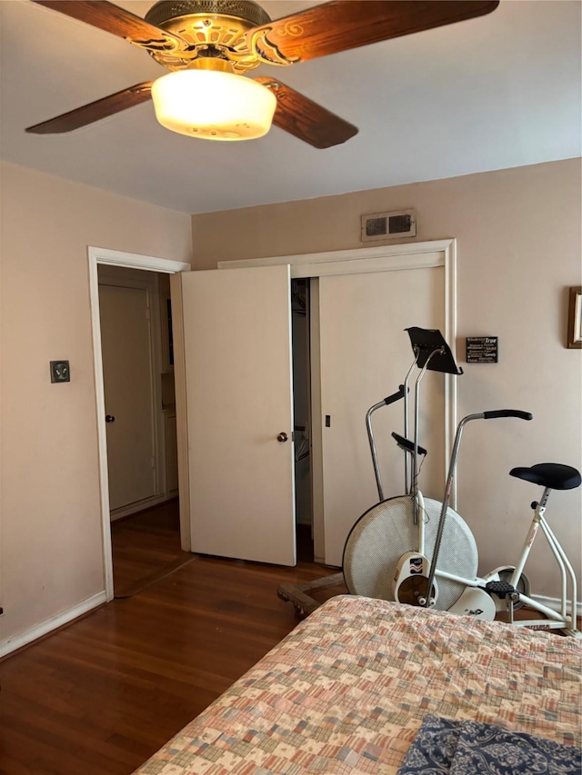 bedroom featuring ceiling fan, dark hardwood / wood-style floors, and a closet