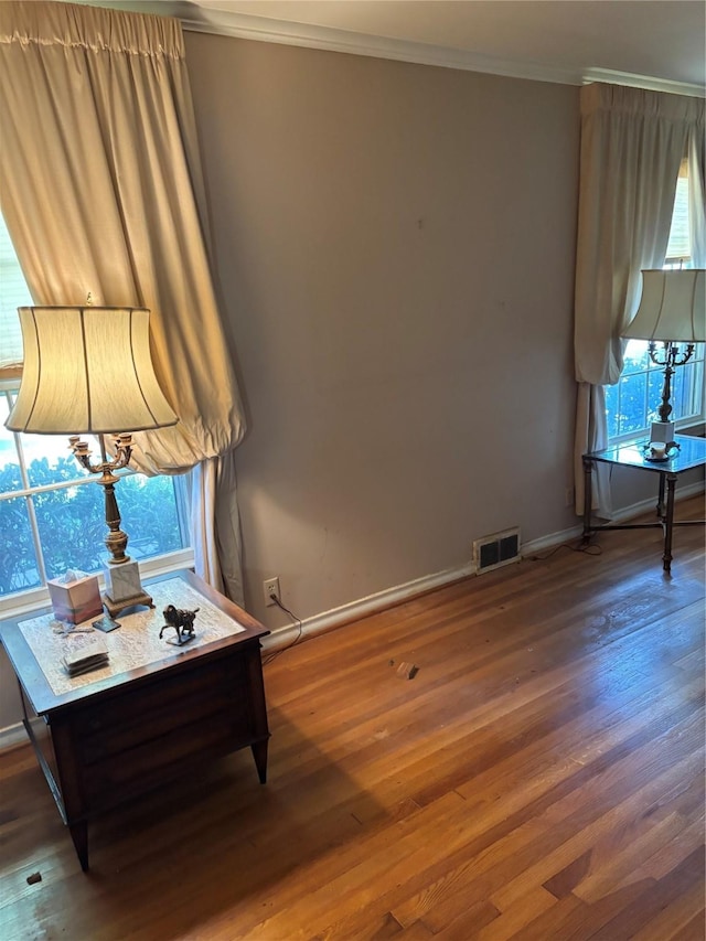 living area featuring ornamental molding and dark hardwood / wood-style floors