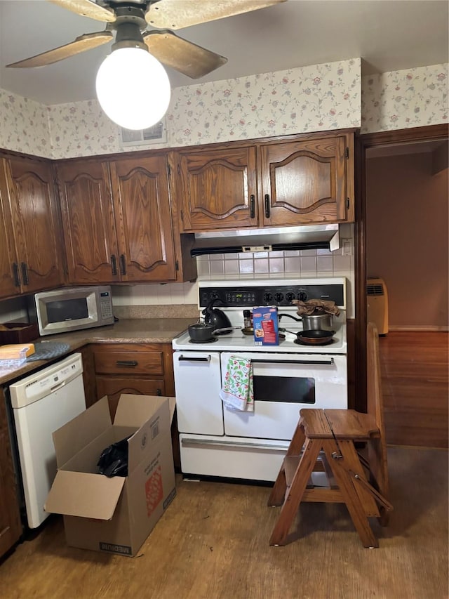 kitchen featuring white appliances, wood-type flooring, decorative backsplash, and ceiling fan