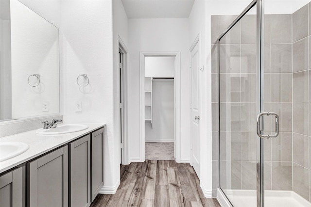 bathroom featuring a shower with door, vanity, and hardwood / wood-style flooring