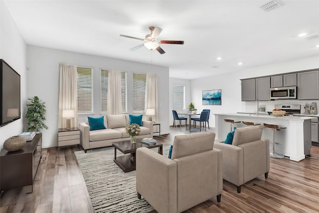 living room featuring light hardwood / wood-style floors and ceiling fan