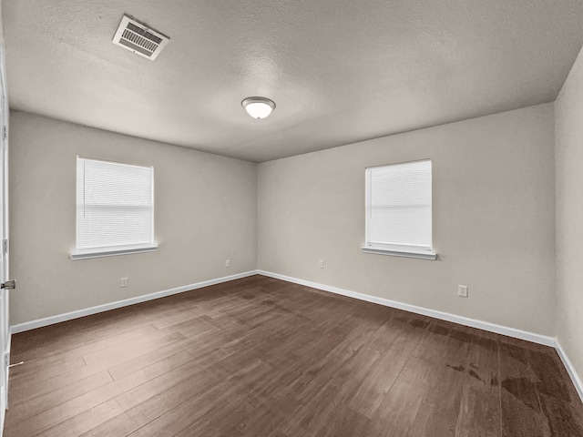 4613 Crenshaw Ave, Fort Worth, TX 76105 - spare room featuring a textured ceiling, dark wood-type flooring, and baseboards