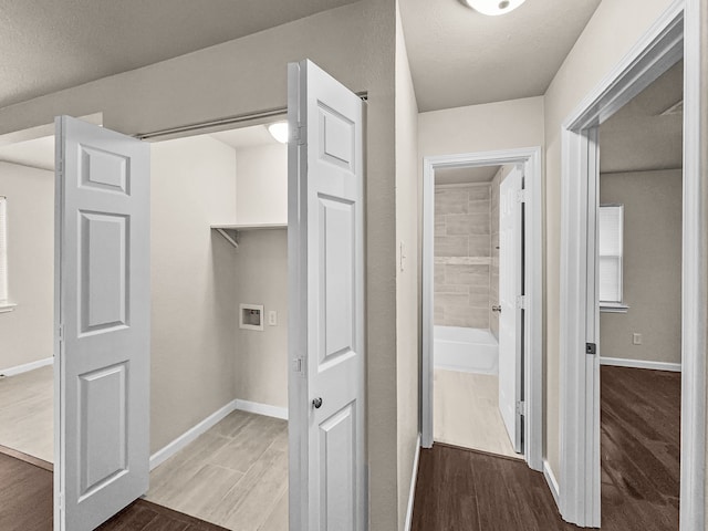 laundry room with dark wood-type flooring, a textured ceiling, and washer hookup