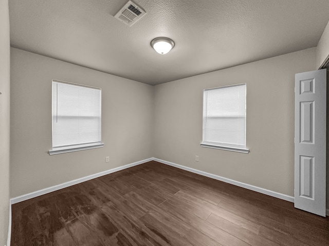 4613 Crenshaw Ave, Fort Worth, TX 76105 - empty room featuring a textured ceiling, baseboards, and dark wood-type flooring