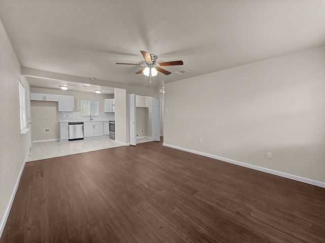 4613 Crenshaw Ave, Fort Worth, TX 76105 - unfurnished living room with wood finished floors, a ceiling fan, baseboards, and a sink