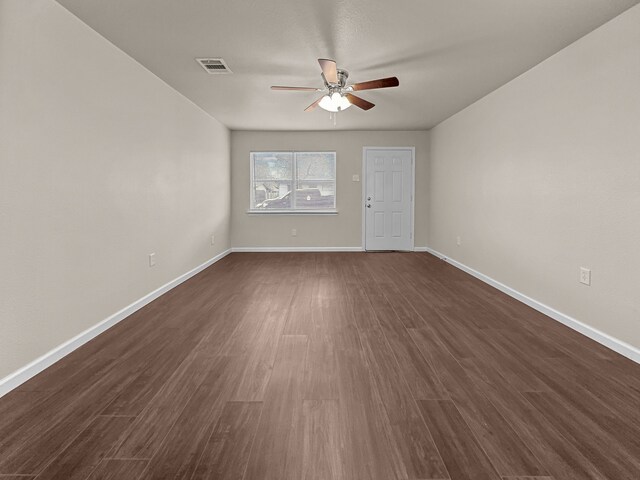 empty room with dark hardwood / wood-style floors and ceiling fan