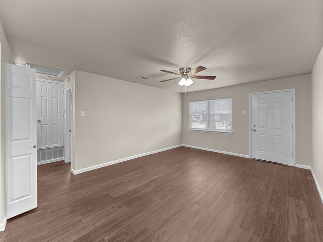 unfurnished room featuring ceiling fan, dark wood-type flooring, and a textured ceiling