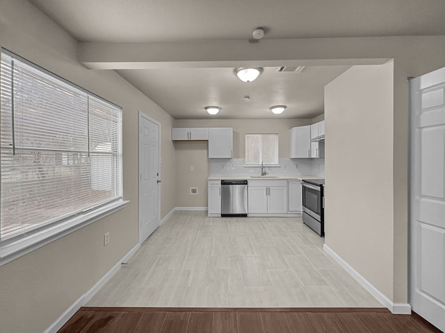 kitchen featuring sink, white cabinetry, tasteful backsplash, light hardwood / wood-style flooring, and stainless steel appliances