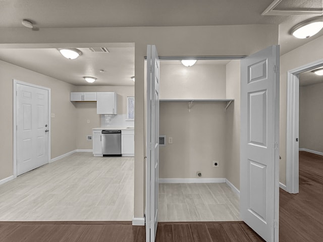 laundry room featuring electric dryer hookup and light hardwood / wood-style floors