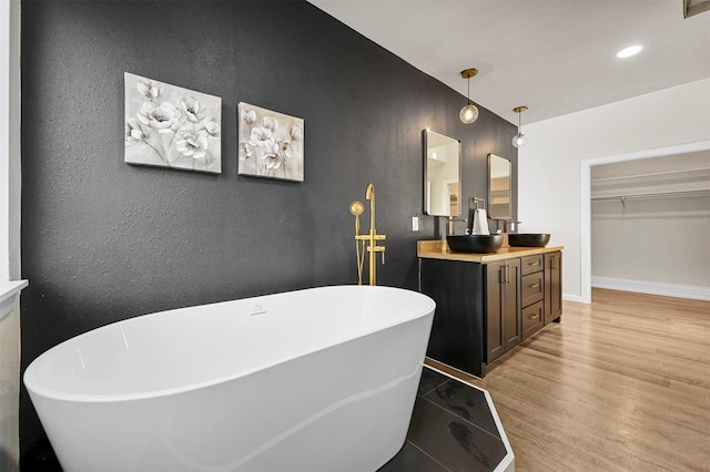 bathroom featuring a washtub, wood-type flooring, and vanity