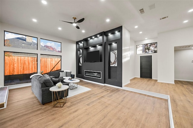 living room featuring light hardwood / wood-style floors and ceiling fan