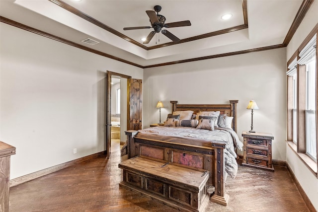 bedroom with ensuite bath, ceiling fan, dark hardwood / wood-style floors, a tray ceiling, and ornamental molding