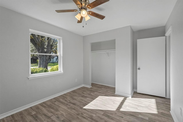 unfurnished bedroom with wood-type flooring, a closet, and ceiling fan