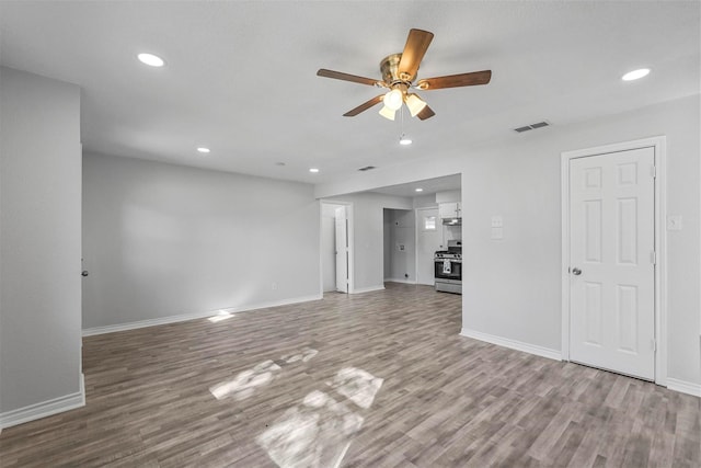 unfurnished living room with hardwood / wood-style flooring and ceiling fan