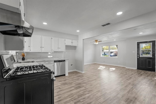 kitchen featuring light wood-type flooring, ventilation hood, stainless steel appliances, sink, and white cabinetry