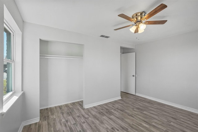 unfurnished bedroom featuring a closet, hardwood / wood-style flooring, and ceiling fan