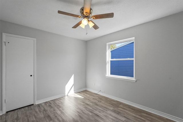 unfurnished room with wood-type flooring, a textured ceiling, and ceiling fan