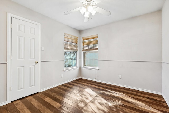 empty room with ceiling fan and dark hardwood / wood-style flooring