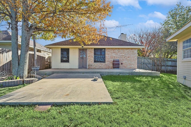 rear view of property featuring a lawn and a patio