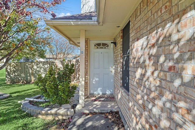 view of exterior entry featuring a yard