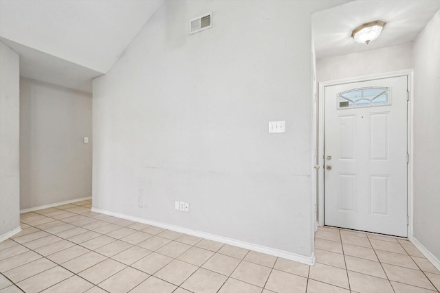 entryway featuring light tile patterned floors and vaulted ceiling