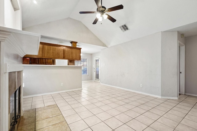 unfurnished living room with ceiling fan, light tile patterned floors, and high vaulted ceiling