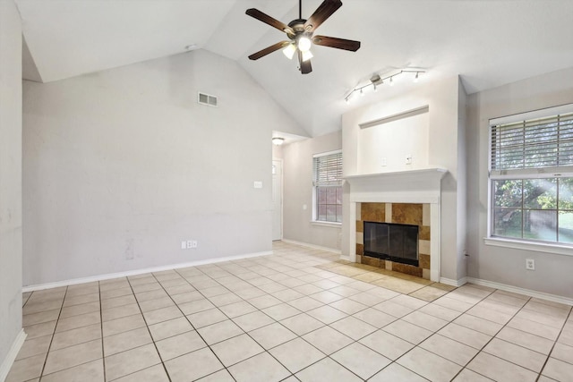 unfurnished living room with ceiling fan, a fireplace, light tile patterned floors, and lofted ceiling