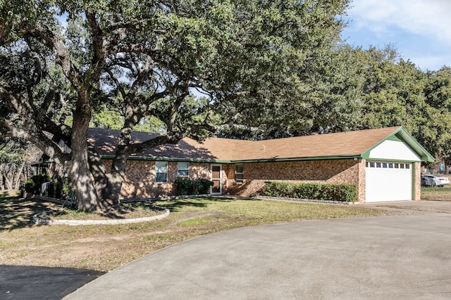 ranch-style home featuring a garage and a front lawn