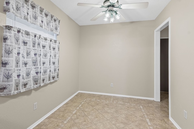 tiled empty room featuring a textured ceiling and ceiling fan