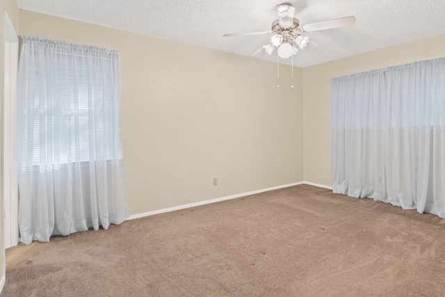 spare room featuring a textured ceiling, light colored carpet, and ceiling fan