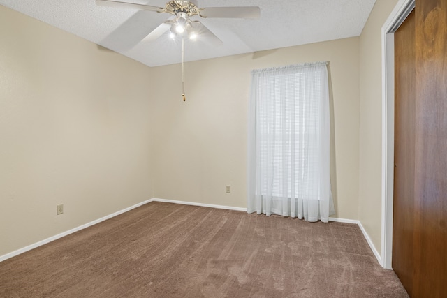 empty room featuring carpet flooring, ceiling fan, and a textured ceiling