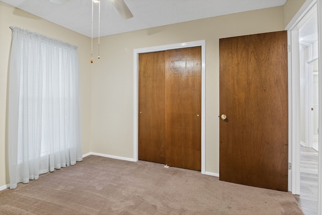 unfurnished bedroom with light carpet, a closet, and ceiling fan